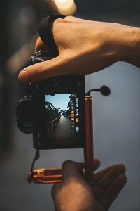 Photo of a photographer holding a camera with an L-Bracket attached to show how it is used.