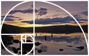 Image of a stunning sunset over Merrill Lake with the Golden Spiral overlay to show how the spiral is used to create balance and harmony in the image.